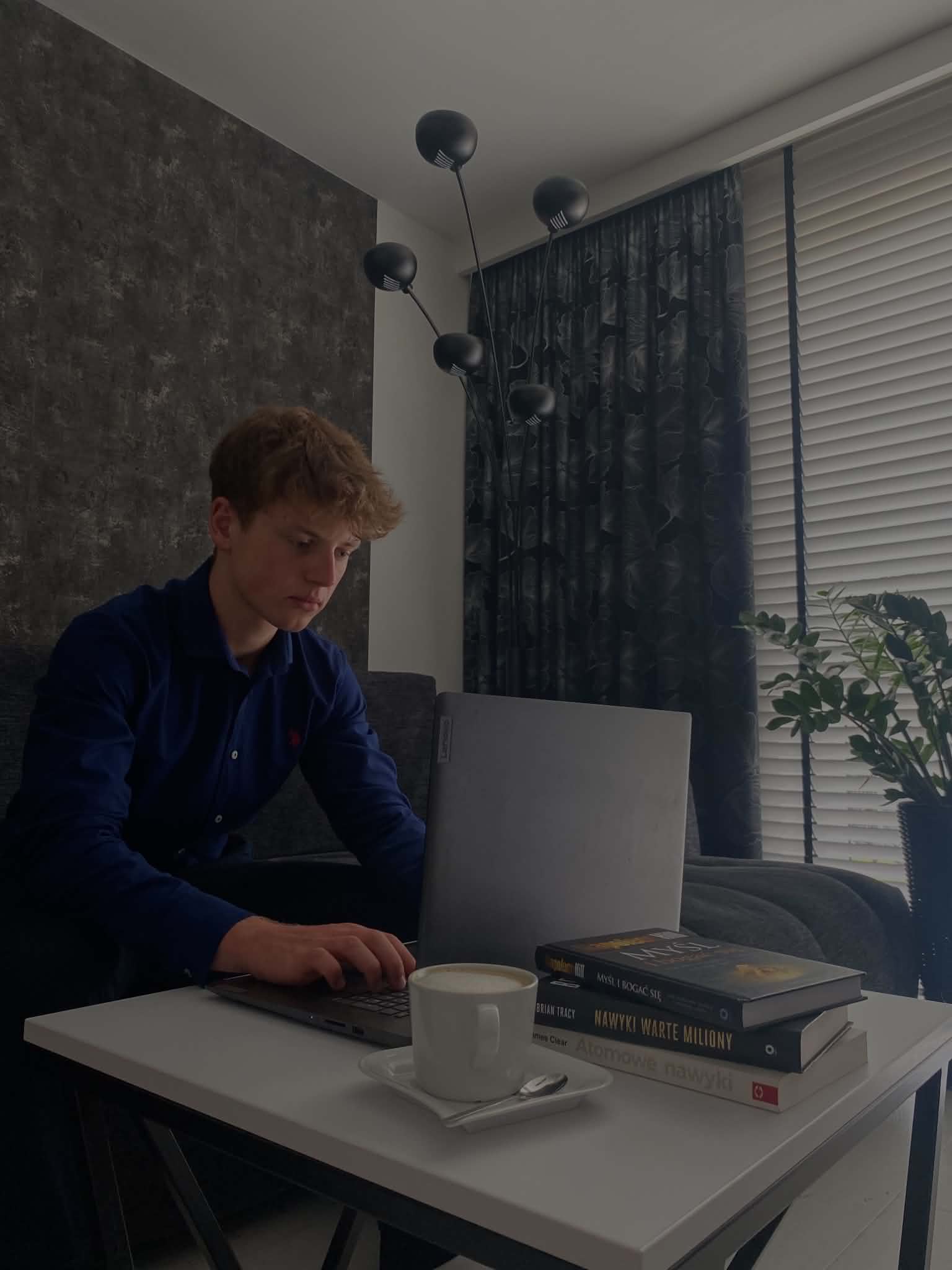 Aleksander Perzyński pracujący przy laptopie nad projektem strony internetowej